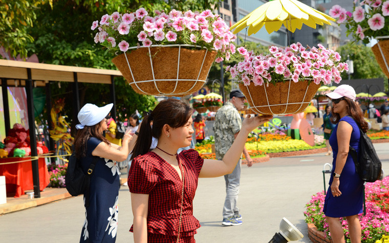 Muôn kiểu tránh nắng của du khách tham quan đường hoa Nguyễn Huệ.