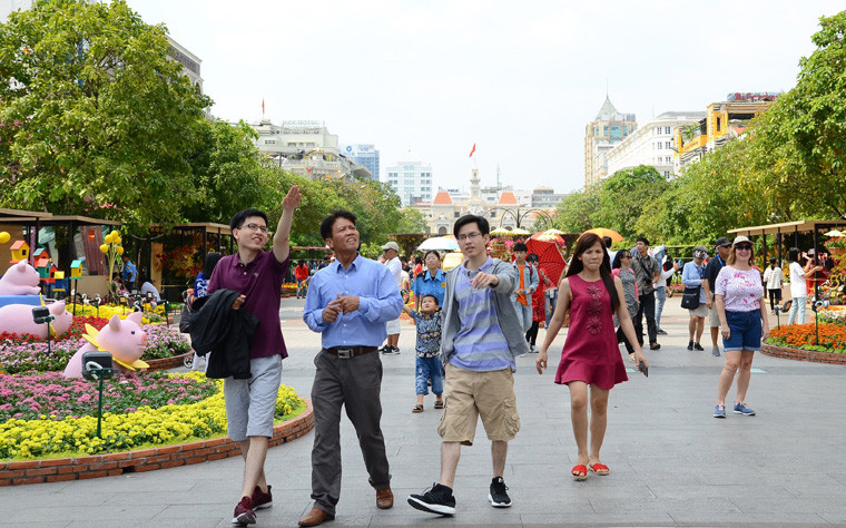 Giới trẻ thích thú dạo chơi trên đường hoa Nguyễn Huệ khoe sắc với hàng trăm loại hoa các loại.