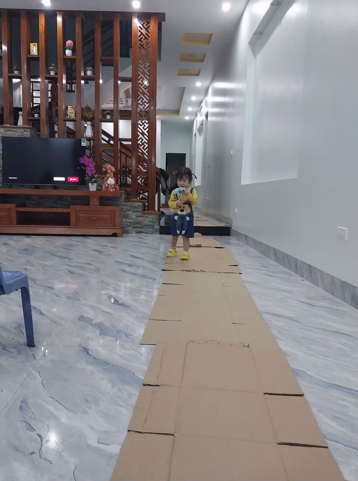 Để tránh trơn trượt ảnh hưởng trẻ nhỏ họ còn xếp cách tấp bìa giấy thành lối đi để an toàn hơn. Ảnh: Nguyễn Oanh