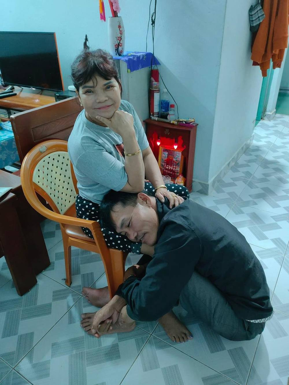 Ông chồng dù có phần hơi không tỉnh táo, nhưng vẫn rất yêu vợ, ôm chặt lấy chân của bạn đời mình và mỉm cười trong lúc ngủ gật.