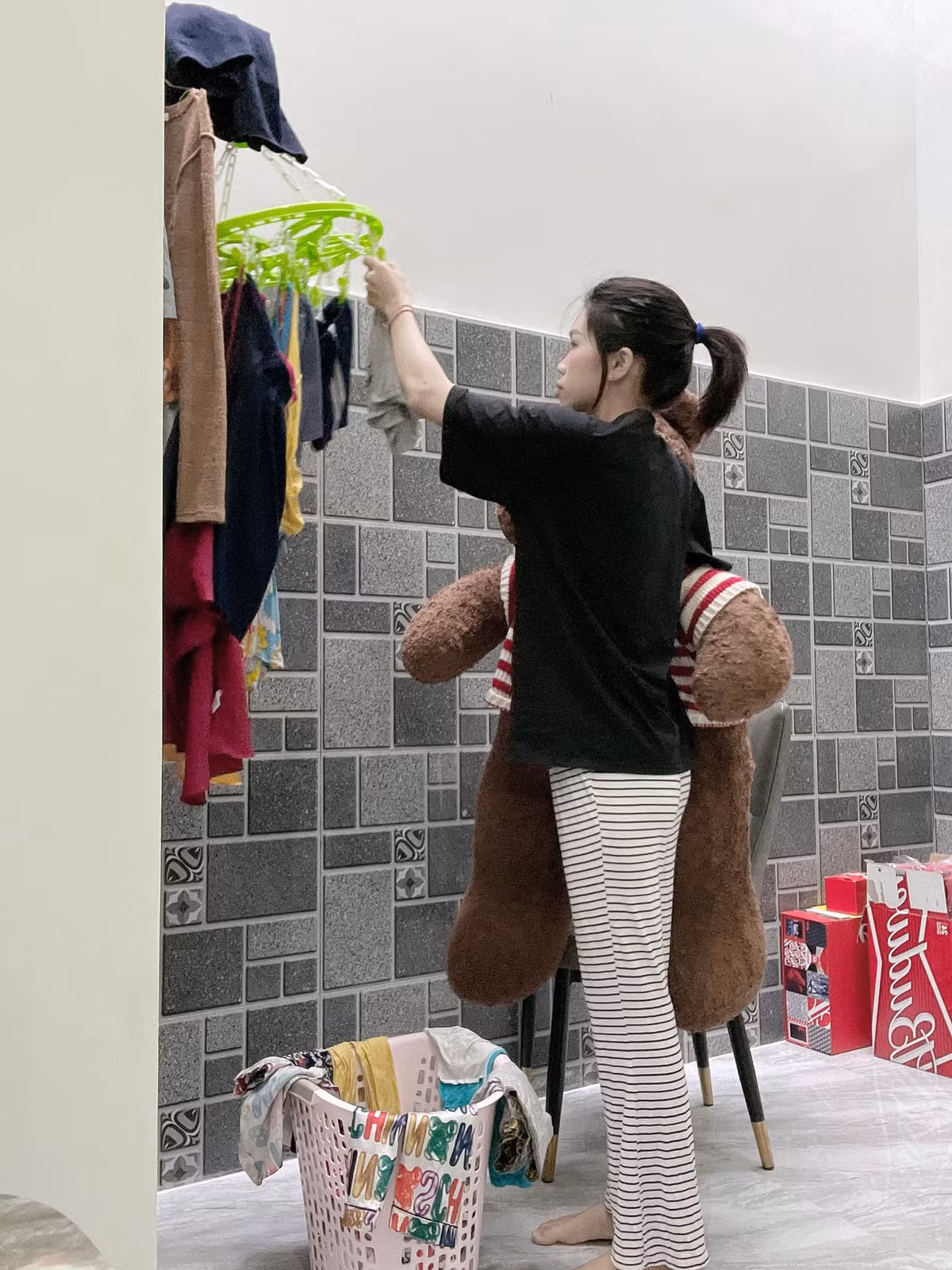 Cô gái một tay ôm gấu bông và một tay hào hứng làm hết việc nhà khiến ai nấy đều phải bật cười. Ảnh: Tạ Thị Thuỳ Vân