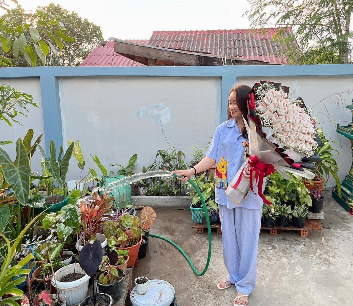 Sau khi nhận được bó hoa này, cô gái vô cùng hào hứng mà cầm theo bất kể mọi lúc, mọi nơi và làm việc nhà. Ảnh: Chửi Thuê