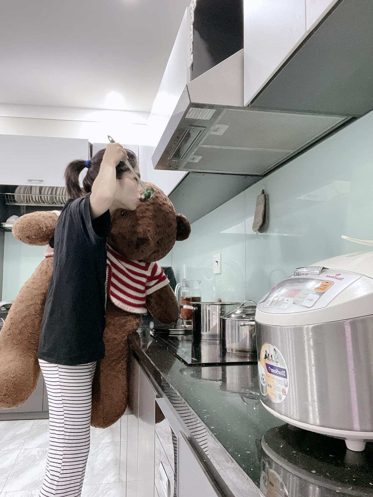 Cô gái dù bận ôm gấu bông thế nhưng vẫn chăm chỉ làm hết việc nhà, từ nấu ăn, phơi quần áo cho đến cọ nhà tắm,... Ảnh: Tạ Thị Thuỳ Vân