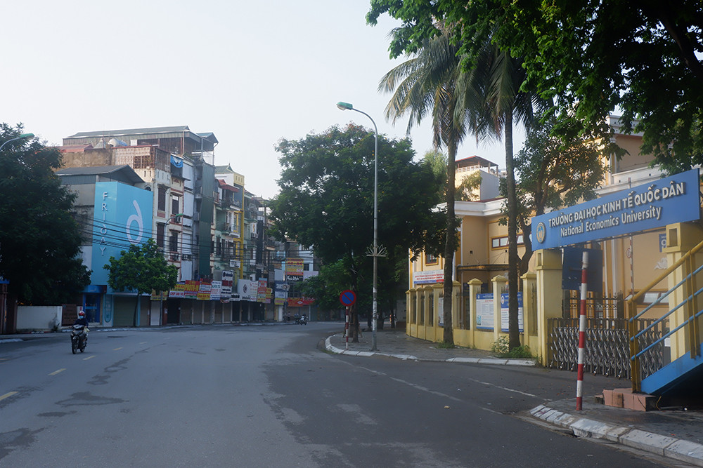 Đoạn đường trước mặt Trường Kinh tế Quốc dân vắng vẻ trong ngày đầu thực hiện giãn cách xã hội.