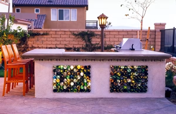 Điểm nhấn ấn tượng cho chiếc bàn đá ngoài trời là những chai lọ nhiều màu sắc, sinh động.