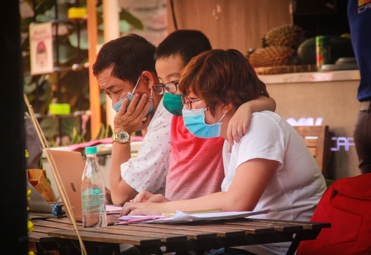 Một gia đình bịt khẩu trang kín mít khi ngồi trong quán cafe tại đường sách.