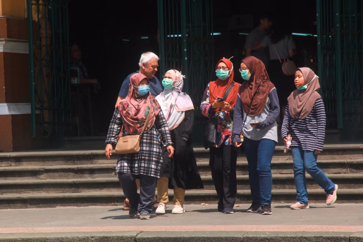 Du khách nước ngoài bịt kín khẩu trang khi tới thăm quan Bưu điện thành phố.