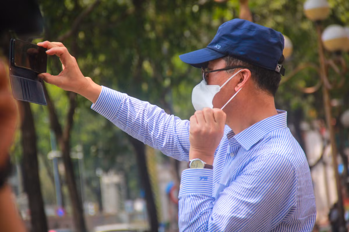 Du khách đeo khẩu trang khi chụp hình check-in tại Bưu điện thành phố.