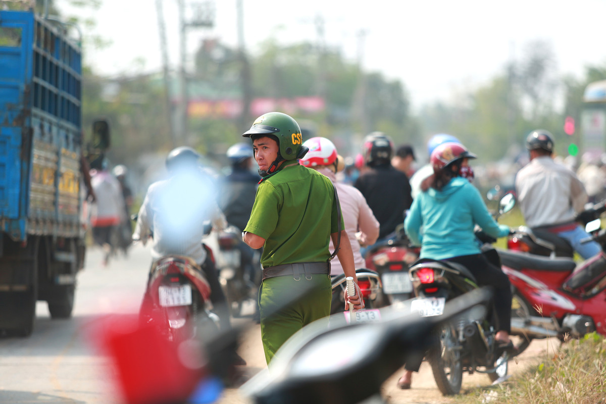 Lực lượng chức năng phải xuống đường dẹp trật tự khu vực phía trước căn nhà vì người dân tập trung quá đông trên đường.