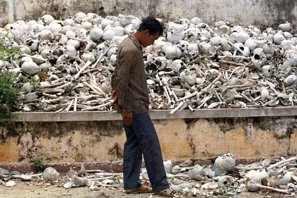 Một người đàn ông đi ngang qua khu vực chất đầy hộp sọ và xương cốt của các nạn nhân thiệt mạng do chế độ diệt chủng Pol Pot tại Bảo tàng diệt chủng Tuol Sleng ở Phnom Penh.