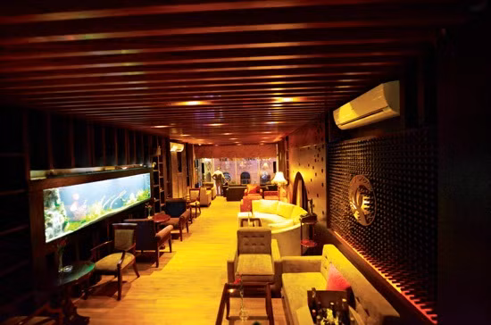 Toàn bộ không gian của quán cafe được bao bọc bởi những lớp gỗ bản lớn ở sàn và trần. Trên tường của quán cafe này có bố trí những bể cá nhằm làm tô điểm cho không gian của quán thêm phần thú vị.