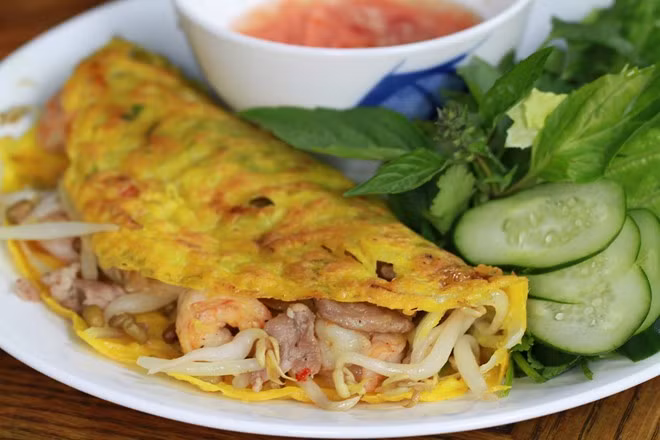Bánh xèo miền Tây thường được tráng trong chảo lớn và có nhân phong phú. Nước chấm đóng vai trò quan trọng. Bánh xèo thường ăn kèm với rau xà lách, cải bẹ canh, húng quế, húng thơm... Ảnh: CMN.