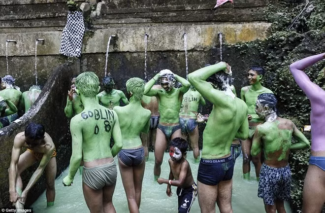 Khi lễ hội kết thúc, các thanh niên tẩy lớp sơn màu xanh bằng nước thánh. Ảnh: Getty