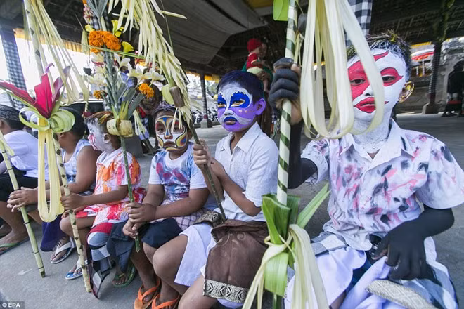 Các bé trai hóa trang thành quỷ nhỏ bằng cách sơn lên mặt nhiều màu sặc sỡ. Ảnh: EPA