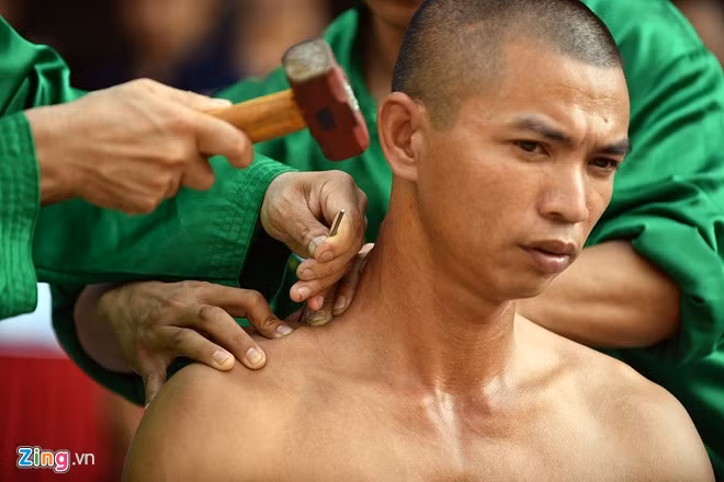 Hai chiếc đinh bằng sắt dài khoảng 20 cm được đóng vào vai người biểu diễn.