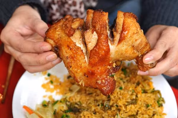 Đĩa cơm rang với đùi gà quay mềm ngậy ăn cùng với cơm được rang săn tơi đậm đà sẽ khiến bạn khó lòng quên được bởi độ “siêu nhiều đạm” cũng như hương vị đặc biệt của món ăn.