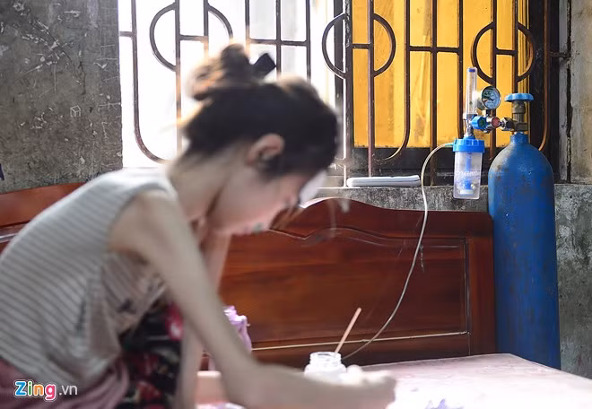 Mỗi buổi chiều, Nhi thường khó thở, thở dốc và phải nhờ đến sự trợ giúp của bình oxy. Bà nội cô bé cho biết, trung bình khoảng 2-3 ngày, em phải thay bình một lần. Có những lúc thời tiết thay đổi, em dùng hết cả một bình, với chi phí đổi oxy là 50.000 mỗi lần. Đây là số tiền khá lớn đối với bà khi mỗi ngày, bà chỉ kiếm được đôi ba chục nghìn từ hàng nước.