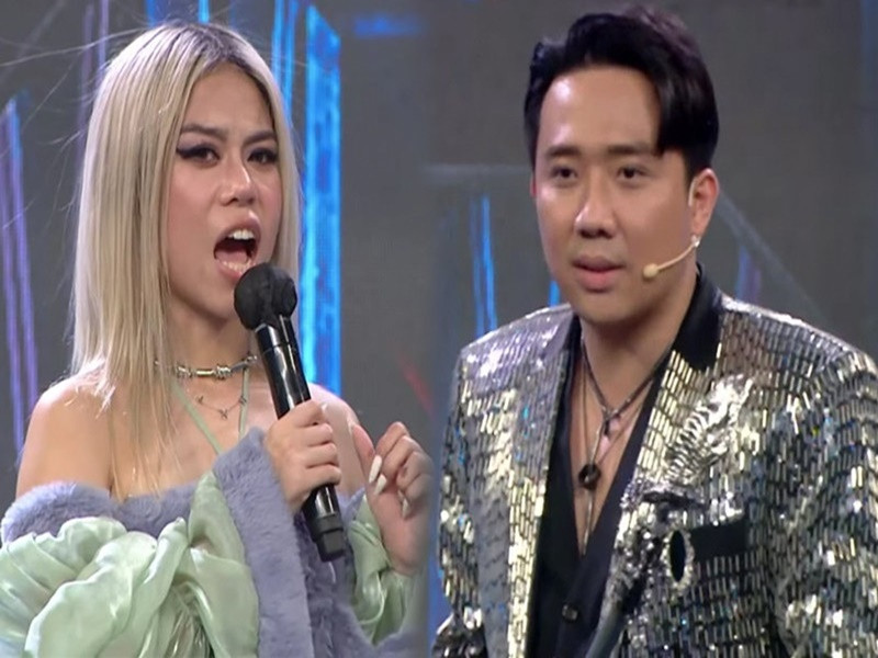 Trong chung kết Rap Việt tháng 1/2022, nghe Tlinh hát "Gái độc thân", Trấn Thành đặt một câu hỏi khá nhạy cảm với thí sinh này: "Em hát bài này là chỉ hát vậy thôi hay đang độc thân?". Không muốn lên tiếng về chuyện tình cảm sau khi chia tay MCK, Tlinh trả lời: "Anh có thể nào đặt một câu hỏi khác tinh tế hơn được không?". Trấn Thành đổi câu hỏi nhưng không khác gì câu trước: "Hiện em có độc thân không?". Cuối cùng, Trấn Thành cũng đổi sang một câu hỏi khác khi thấy Tlinh cười trừ. Ảnh: Doanh nghiệp và tiếp thị