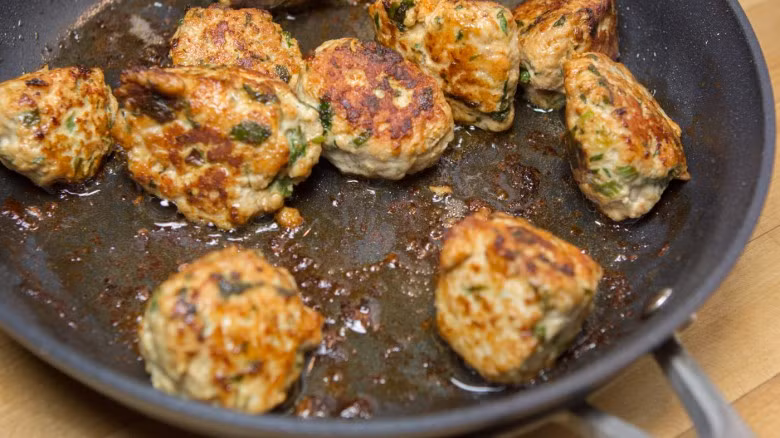 Bắc chảo lên bếp, cho dầu ăn vào rồi cho thịt gà viên vào rán cho vàng đều hai mặt. 