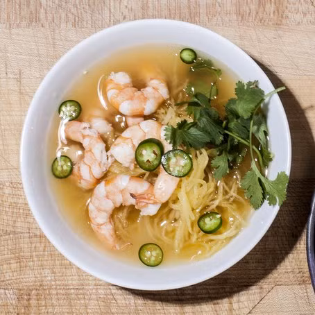 Canh tôm nấu xả: Tôm để nguyên vỏ rồi đảo qua với dầu ăn đến khi tôm chuyển màu hơi hồng thì cho gừng, xả, tỏi và hành vào đảo cùng khoảng 3 phút. Cho nước dùng vào đun nhỏ lửa khoảng 30 phút cho các hương vị quện đều với nhau thì lọc qua lưới, chỉ lấy nước dùng và tôm. Đun tôm với nước dùng thêm khoảng 2 phút nữa cho tôm mềm hẳn, khi ăn rắc thêm rau mùi và ớt. (Nguồn ảnh: Bonappetite) 