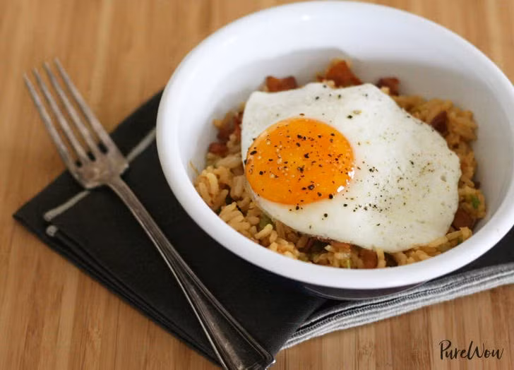 Cơm rang thịt hun khói và trứng: Với hai nguyên liệu có thể dự trữ sẵn trong tủ lạnh này, bạn chỉ cần cho thịt hun khói vào chảo nóng cho chảy bớt mỡ và giòn rồi xúc ra để riêng. Tận dụng phần mỡ này, cho hành tỏi vào phi thơm rồi cho cơm vào đảo, nêm gia vị gồm nước tương, dấm gạo, dầu hào và tương ớt vào rang tiếp đến khi hạt cơm săn lại. Đập một quả trứng vào giữa chảo cơm rồi đảo nhanh tay. Khi ăn để thêm một quả trứng ốp lên trên. 