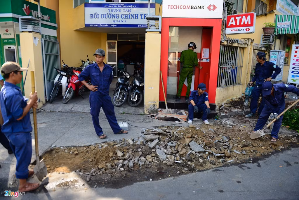 Trước cửa Trung tâm Bồi dưỡng chính trị của quận, công nhân tiếp tục phá dỡ nền xi măng bị bong tróc, sau đó sẽ tráng lớp bê tông mới.