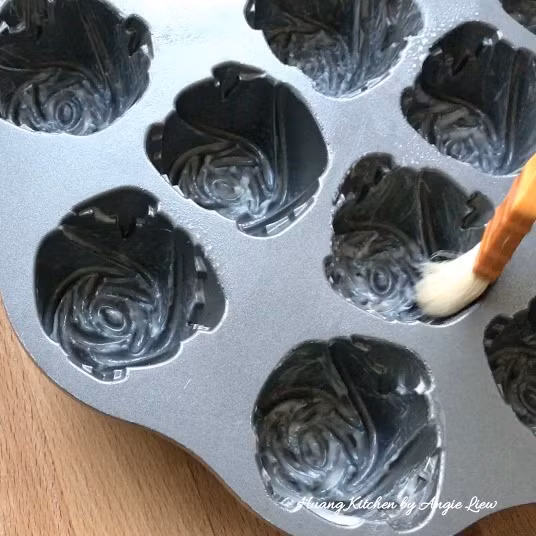 Xịt dầu chống dính lên khuôn bánh hình hoa hồng. 