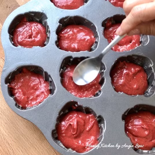 Dùng muôi múc kem chia đều bột vào khuôn rồi dùng thìa ấn nhẹ xuống để bột bám đều vào khuôn. 