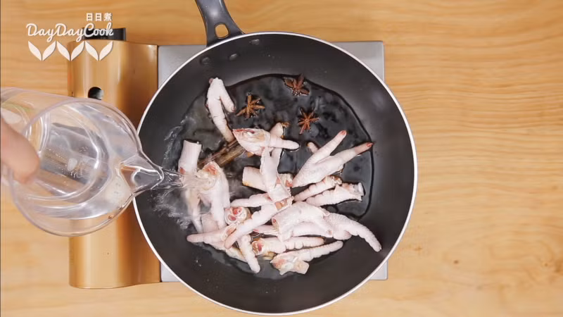 Bắc chảo lên bếp, cho chân gà, hoa hồi, quế nước tương đen vào. Đổ nước cho ngập rồi bật lửa to nhất cho sôi, sau đó hạ bớt lửa và đun tiếp khoảng 10-15 phút. Vớt ra để ráo.