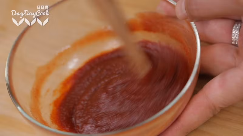 Trộn đều sốt cà chua ketchup với tương ớt Hàn Quốc và đường để làm nước sốt cho món chân gà.