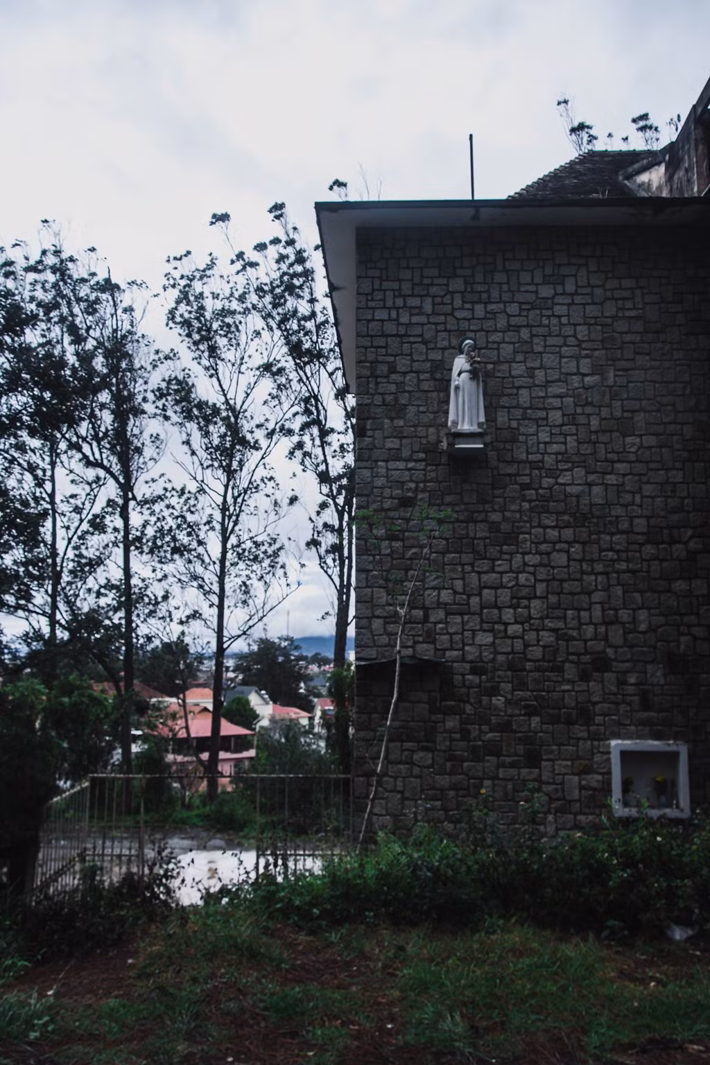 Tượng Đức Mẹ phía bên hông nhà nguyện. Nơi đây đã bị bỏ hoang nhưng người dân vẫn đến đặt hoa tươi dưới bức tượng này. 