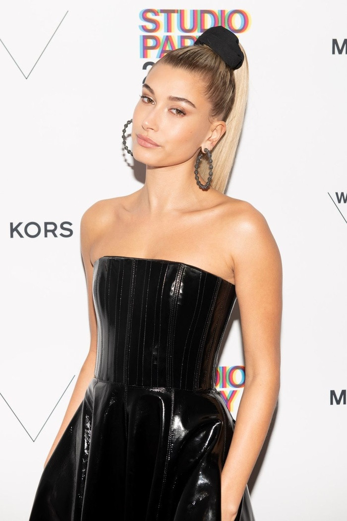 Hailey Baldwin dùng chun buộc cao mái tóc dài khoe bờ vai và lưng gợi cảm.