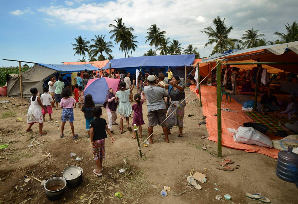 Một số người đã phàn nàn rằng họ không được để ý tới, hoặc phải nhận sự cứu trợ chậm chễ. “Không cứ sự hỗ trợ nào ở nơi này cả,” Multazam 36 tuổi nói. Anh và hàng trăm người khác đang sống dưới những tấm bạt trên một cánh đồng lúa khô bên ngoài làng Pemenang. Thời tiết khô hạn gần đây cũng góp phần cho việc thiếu nước sạch trầm trọng.