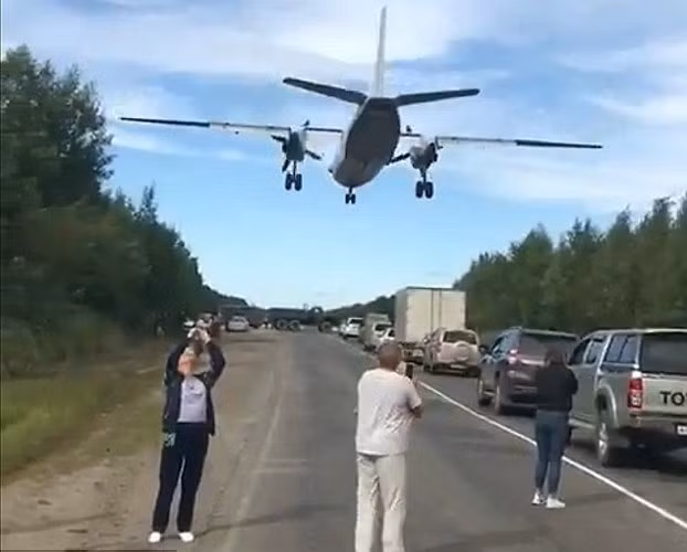 Người đi đường thích thú quay phim cảnh phi cơ quân sự bay sát ngay trên đầu họ.