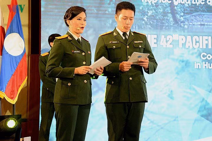 Hình ảnh 2 người dẫn chương trình của quân đội Việt Nam trên sân khấu sự kiện.