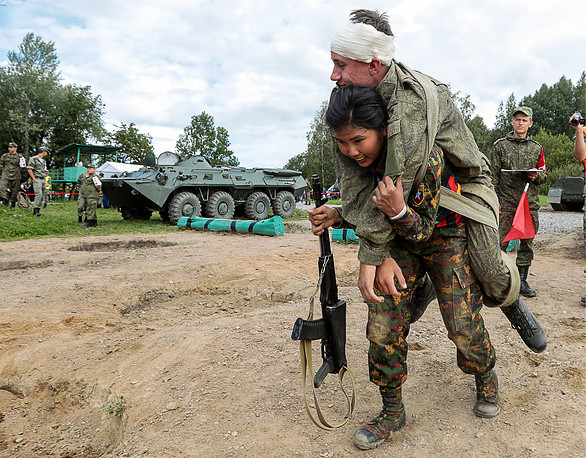 Ở phần thi cứu thương, nhiều nữ quân y phải cõng "thương binh" nặng tới hàng trăm kilograms. Trong ảnh là một nữ quân y của đội Myanmar đang cõng một người lính Nga trên vai. Nguồn ảnh: TASS.