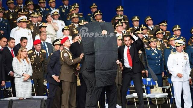 Một góc máy khác, có thể thất các nhân viên cận vệ của ông Maduro đã phải khá vất vả mới có thể che chắn hết được cho Tổng thống Venezuela. Trong khi đó, các quan chức và sĩ quan xung quanh ông hoàn toàn không có động thái gì. Nguồn ảnh: Sina.