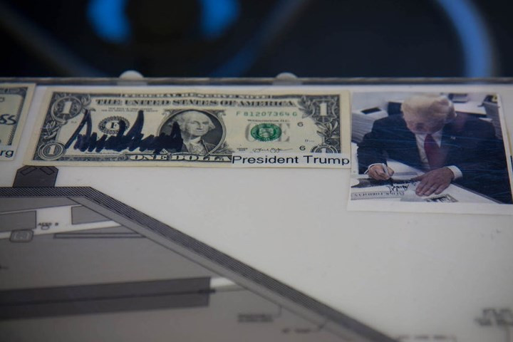 Những người nổi tiếng thăm tàu sân bay Ford, như Tổng thống Donald Trump, thường ký lên đồng tiền Mỹ đặt dọc theo đường viền của bảng Ouija này.