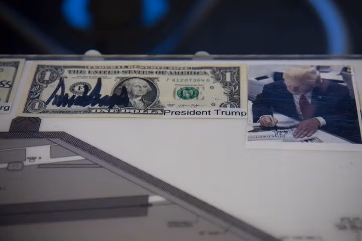 Những người nổi tiếng thăm tàu sân bay Ford, như Tổng thống Donald Trump, thường ký lên đồng tiền Mỹ đặt dọc theo đường viền của bảng Ouija này.