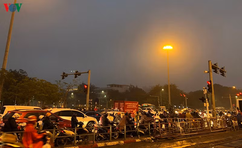 Ngã tư Kim Liên-Đại Cồ Việt những người đi xe máy áo mưa kín mít co ro trong cái lạnh chờ đợi vượt ngã tư.