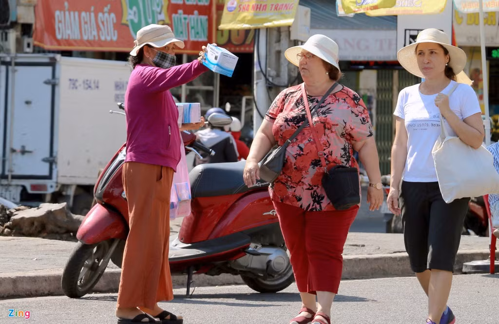Chưa bao giờ dịch vụ khẩu trang lại xuất hiện nhiều và người bán ra tận lòng đường mời chào như hiện nay ở thành phố biển. Ảnh: An Bình.