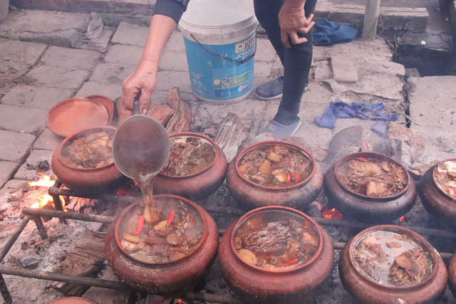 Các thợ nấu cá đang chế thêm nước vào nồi cá. Nước dùng liên tục được đổ thêm để cá luôn trong tình trạng không bị khô.