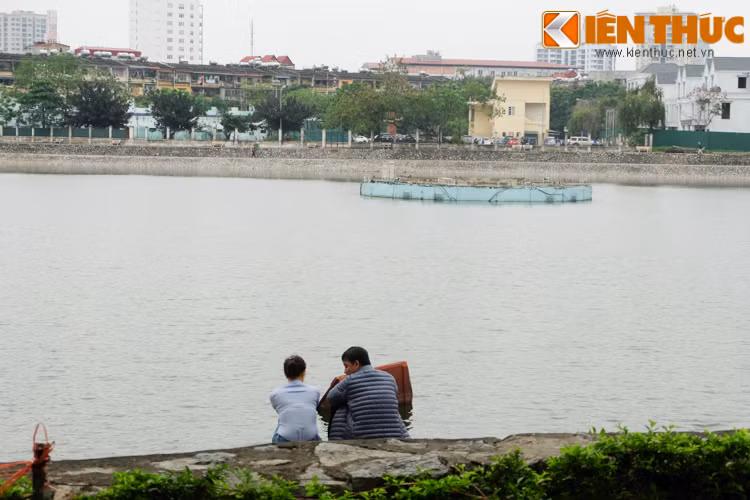 Đôi bạn ngồi tâm sự trước hồ nước trong xanh.