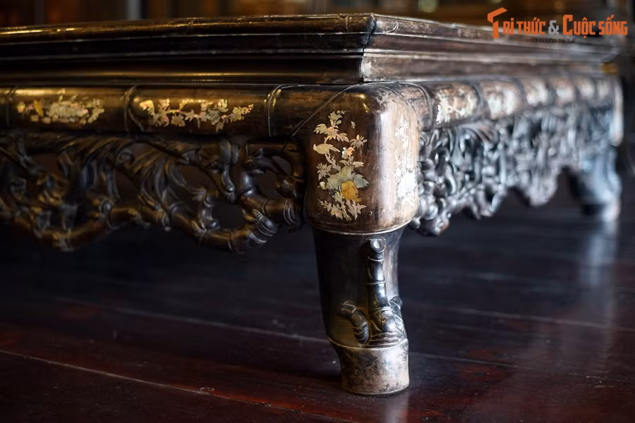 Đồ ngự dụng của vua Thiệu Trị (1841-1847), nhất là đồ gỗ, thường không sơn thếp, đề tài trang trí chủ yếu là cúc hóa vân, trúc hóa long, triền chi… nét chạm tuy mảnh nhưng sâu và rất tinh tế. Ảnh: Sập gụ cẩn xà cừ đặt trong cung đình triều Nguyễn (hiện vật của Bảo tàng Cổ vật Cung đình Huế).