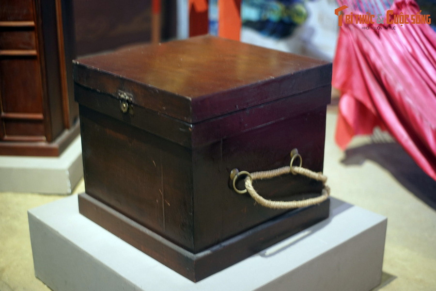 Một người cầm hộp đựng sách vở của Tiến sĩ đi sau võng cáng. Những chiếc hộp này thường được đóng bằng gỗ, có khóa và cánh cửa giống như một chiếc tủ nhỏ, có thể có quai xách hoặc không.