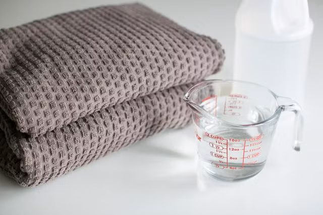 Loại bỏ cặn xà phòng: Các acid acetic trong giấm trắng phá vỡ bất kỳ dư lượng xà phòng bám chặt trên quần áo, khăn, chăn… Dư lượng này có thể gây kích ứng làn da nhạy cảm, đặc biệt là ở trẻ sơ sinh và trẻ nhỏ. Thêm một chén giấm trắng vào chu kỳ xả nước để loại bỏ xà phòng tích tụ. Sau đó thêm hai chén giấm vào chu kỳ xả nước cuối cùng khi giặt khăn tắm, khăn trải giường và chăn.