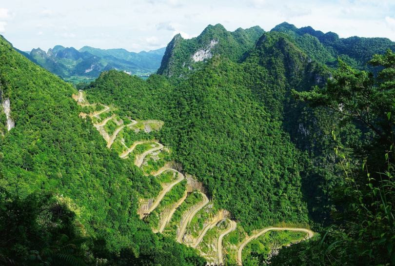 Trong lớp mây trắng bồng bềnh, bảng lảng hơi lạnh của núi rừng hoang sơ, những khúc cua của đèo Mẻ Pia xếp tầng tựa như những nấc thang dẫn lên đỉnh trời. Cảnh vật nơi đây mở ra bao la đến rợn ngợp.