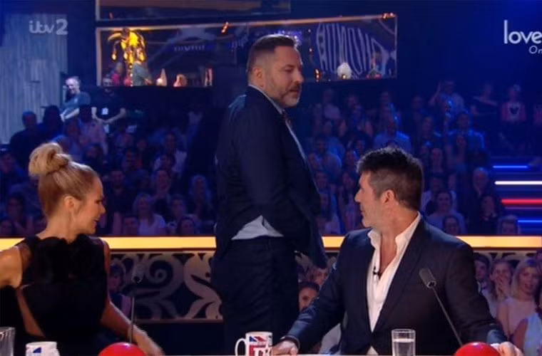 Mọi việc bắt đầu khi MC của chương trình, Stephen Mulhern kể lại chuyện một người đàn ông có hình xăm khuôn mặt 2 MC nổi tiếng Ant và Dec trên mông trong số đầu của chương trình. Stephen bật mí với Simon Cowell rằng một trong số những vị giám khảo của Britain’s Got More Talent cũng có hình xăm chân dung Simon ở bàn tọa. Để chứng minh cho điều đó, giám khảo Britain’s Got More Talent khoe bàn tọa ngay trên truyền hình. (Ảnh: ITV)