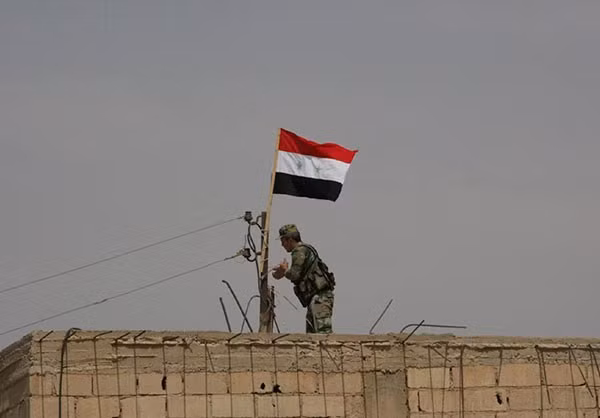 Lá cờ Syria tung bay trên một tòa nhà ở Quneitra, miền nam nước này. Ảnh: FNA.