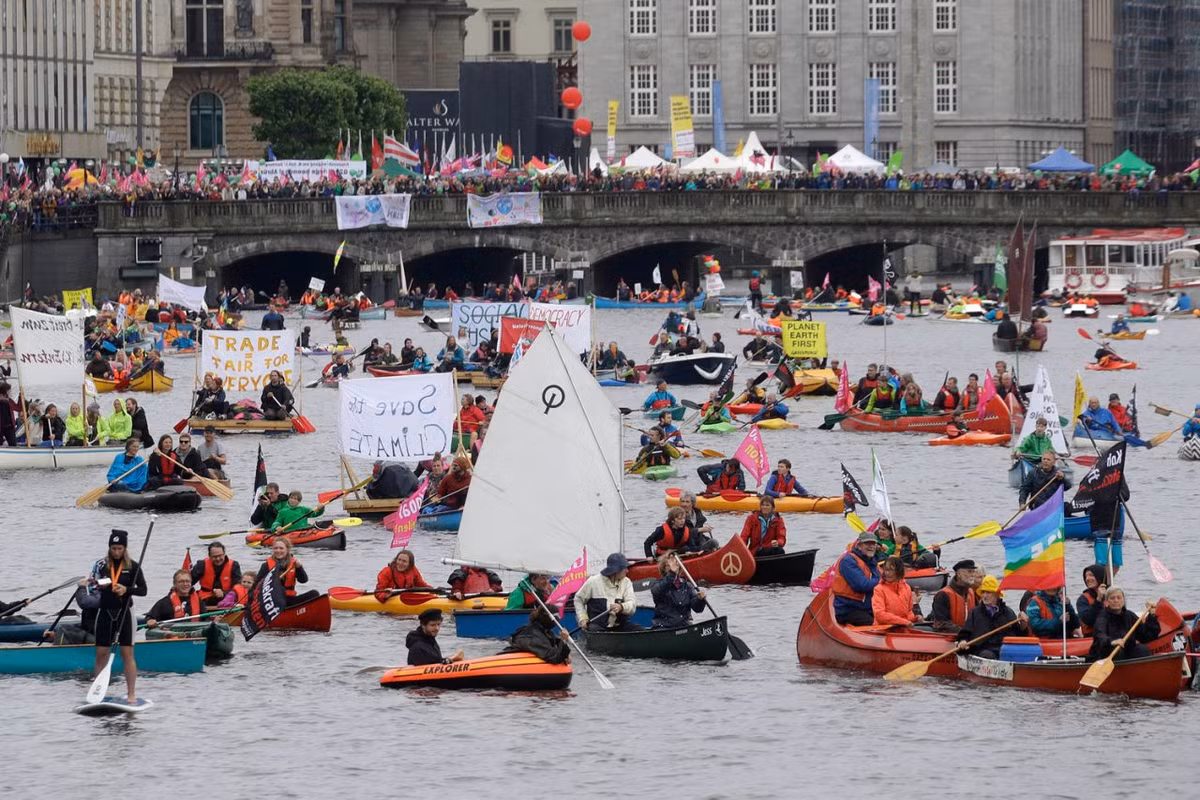 Người dân mang theo nhiều biểu ngữ khi tham gia cuộc biểu tình phản đối G20 ở Đức. Ảnh: Yahoo News.